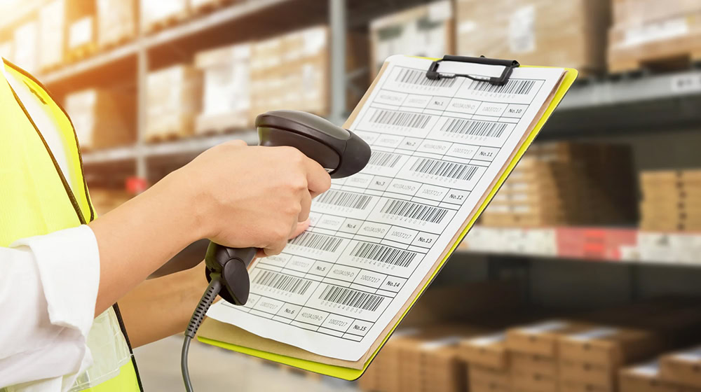 Handheld scanner reads a barcode for an employee on a clipboard.