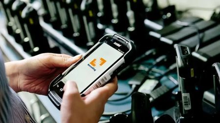 Handheld barcode scanner in a technicians hands.