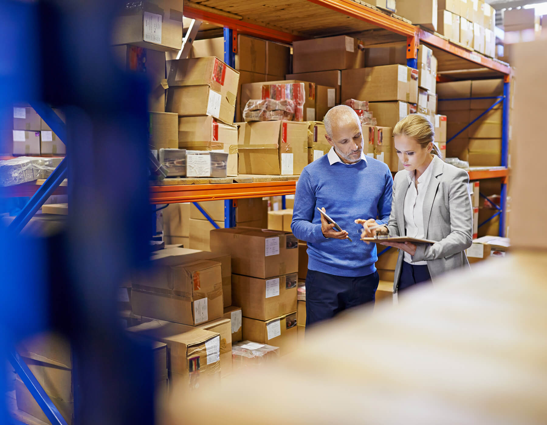 Employees check a tablet while ensuring they have full inventory and asset management in place.
