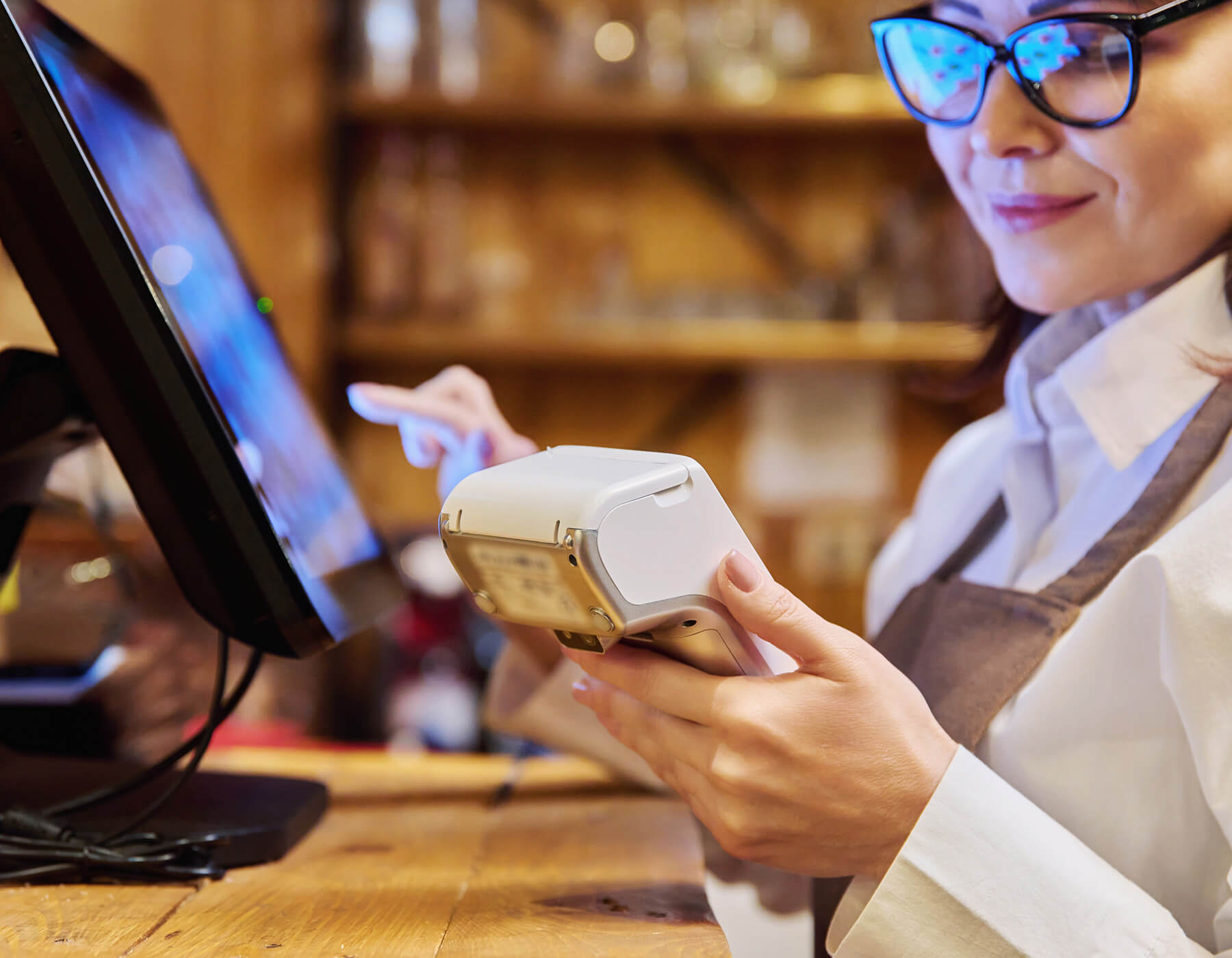 Retail working using POS and retail technology at a point of service kiosk.