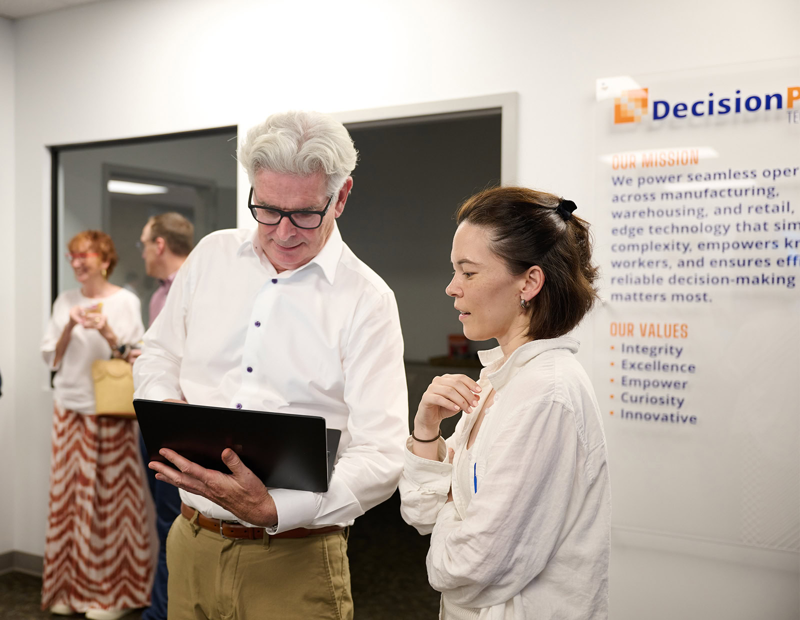 DecisionPoint CEO and employee discuss what is on their laptop screen.