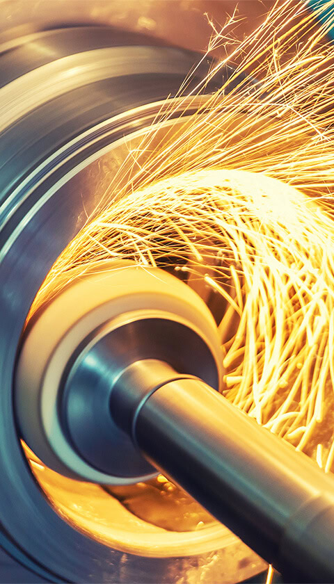 Automated tools ream out the center of a large piece of metal for manufacturing.