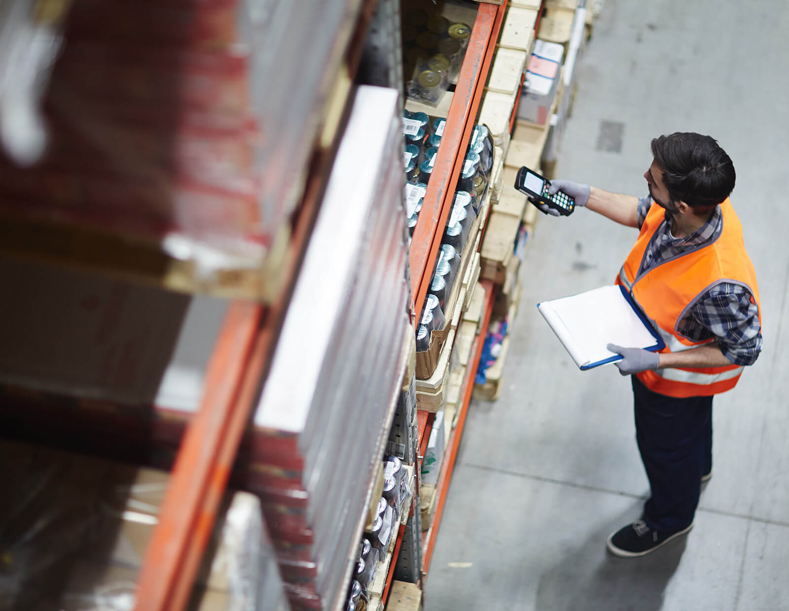 Employee scans items on a large rack using a mobile device handheld scanner.
