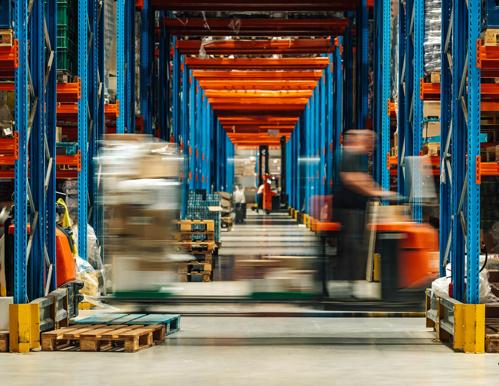 Warehouse showing movement of a forklift moving while employees move goods.