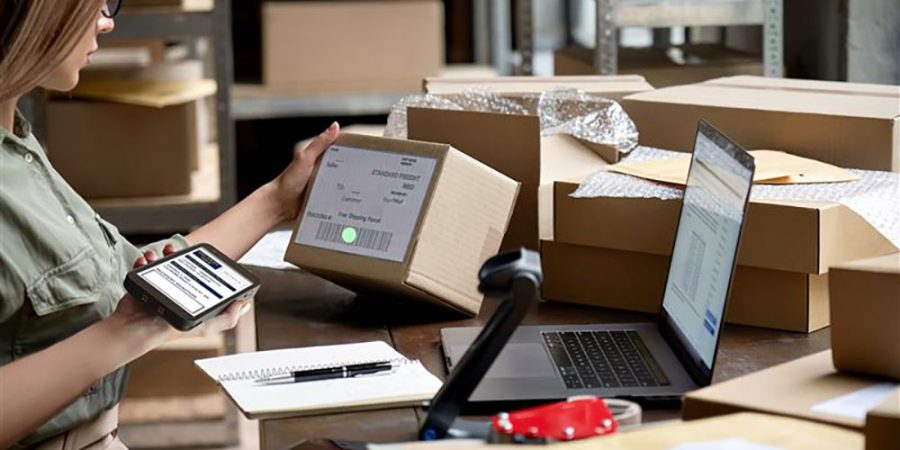 A woman employee scans a barcode with a Datalogic memory device with a mobile device.