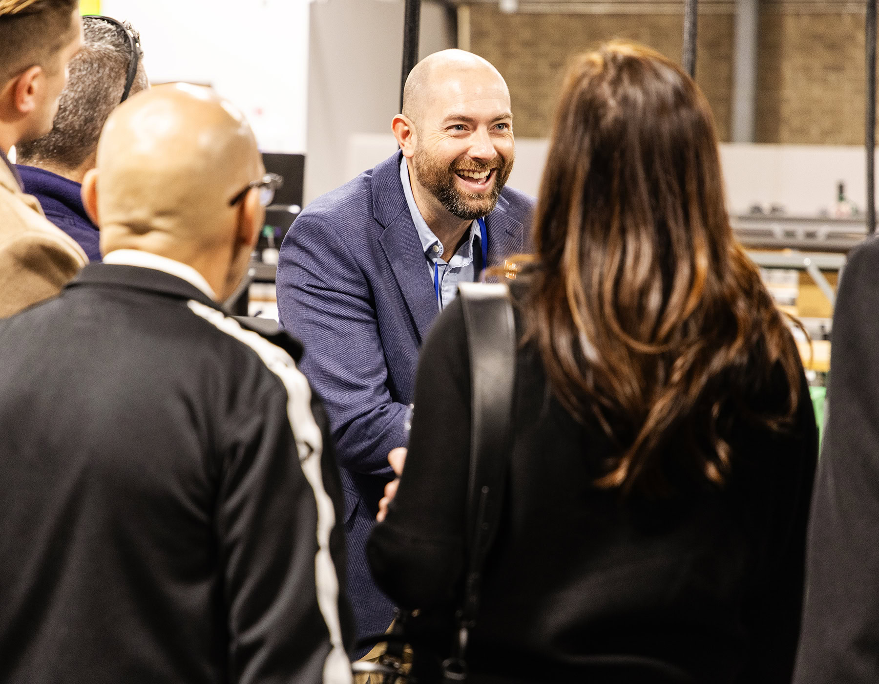 A smiling man talks about DecisionPoint Careers to other employees on site during an orientation.