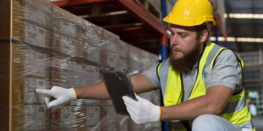 A warehouse employee uses a mobile device from Zebra (ET401)