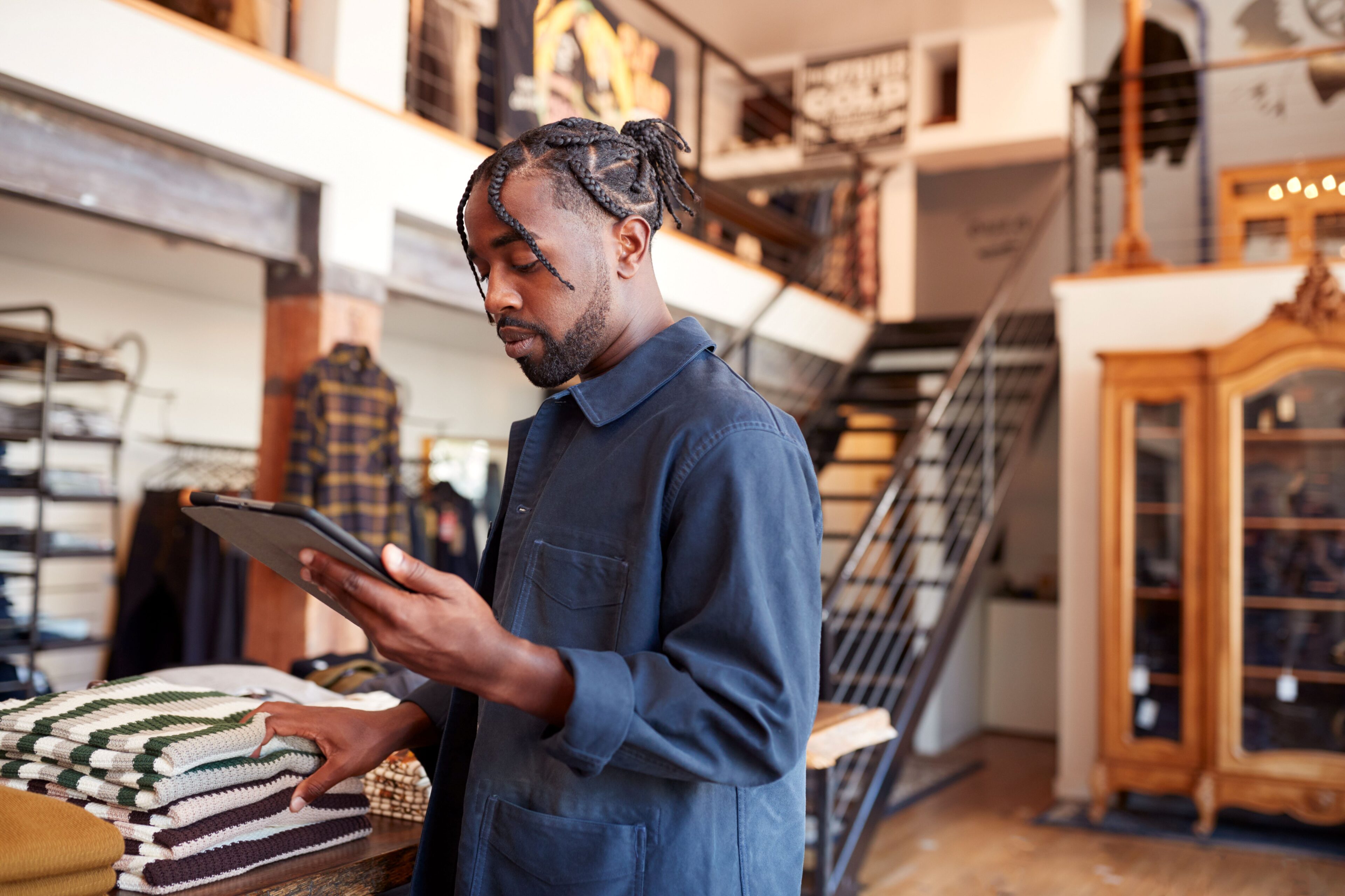 Retail associate checking inventory on a tablet, an everyday test of asset visibility
