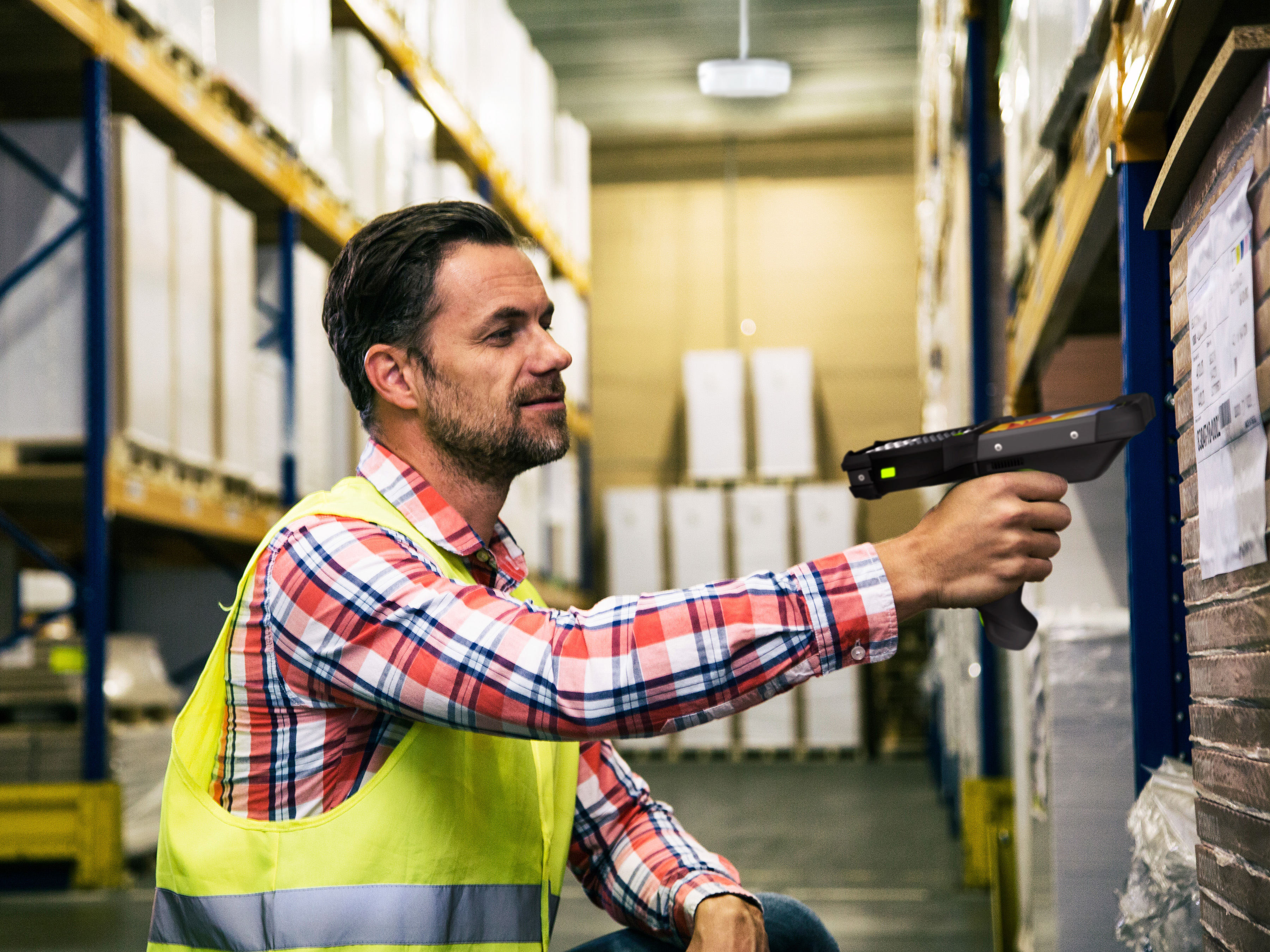 Warehouse associate using a handheld scanner in a warehouse mobility workflow.