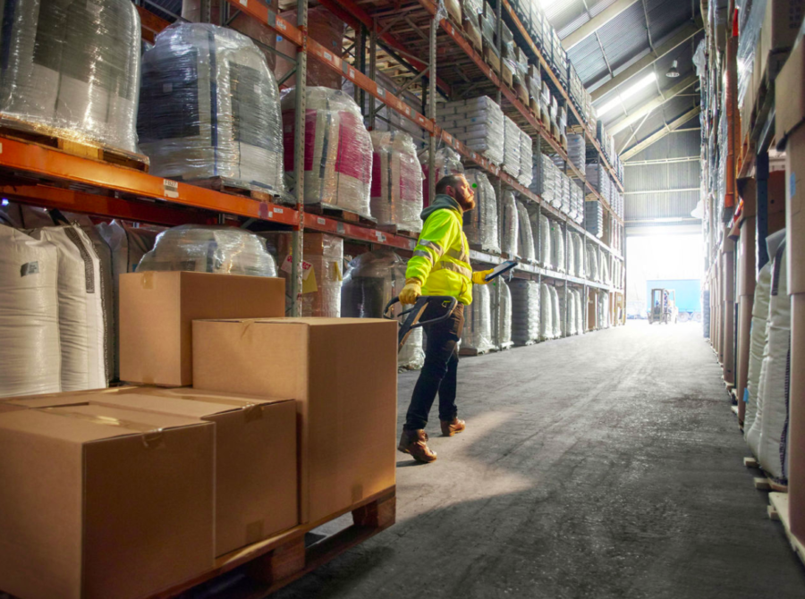 warehouse worker using a rugged Zebra tablet to scan a building supply delivery order at a jobsite